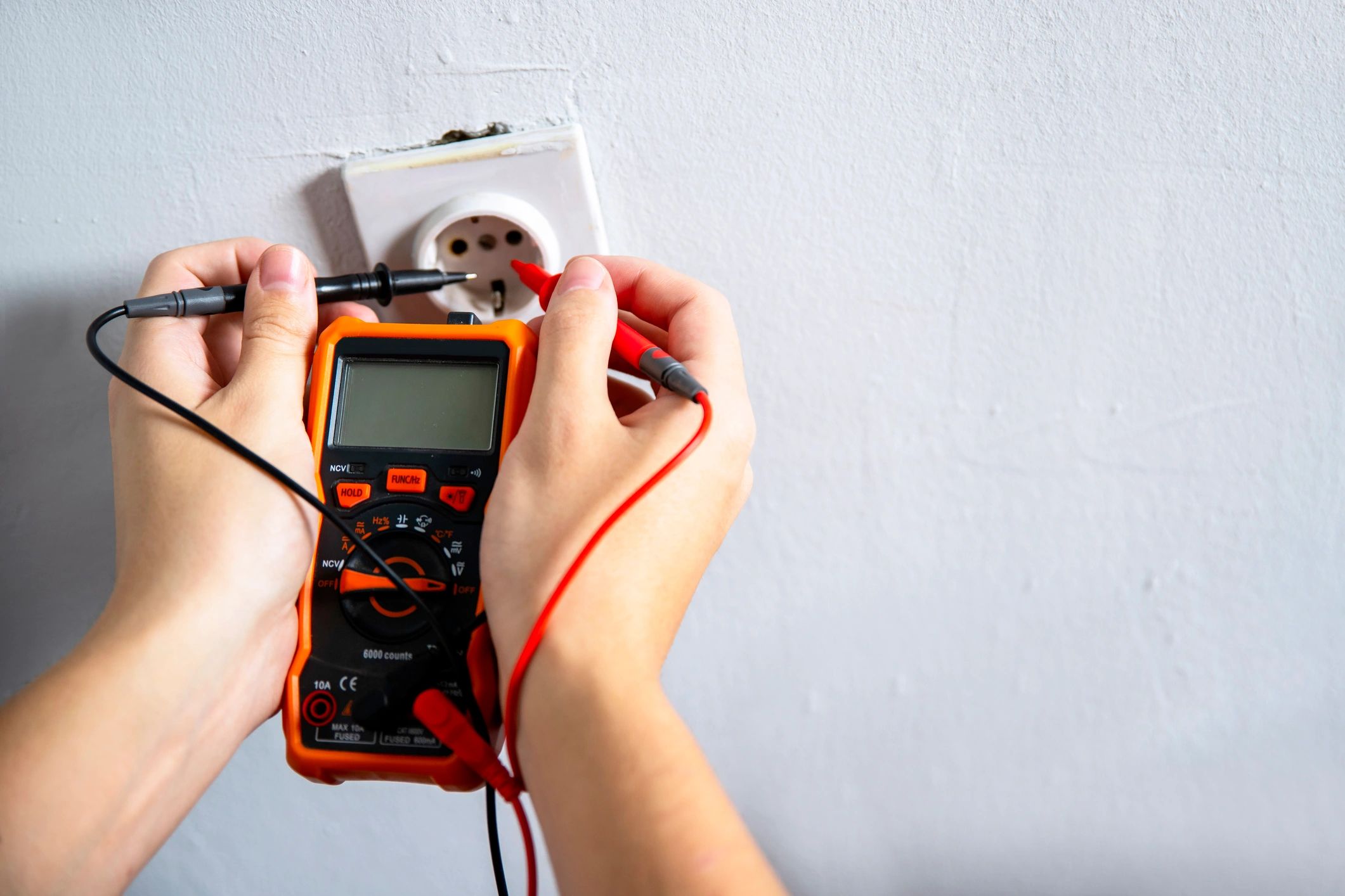 Technician using a digital multimeter during power safety inspection